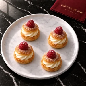 Four Raspberry & Vanilla Choux canapés on a marble plate