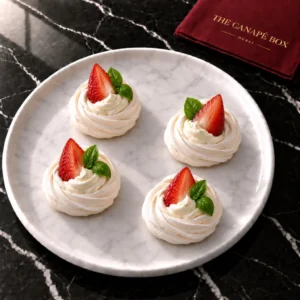 Four Strawberry & Basil Pavlova canapés on a marble plate