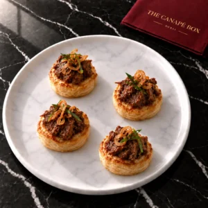 Four portions of Beef Rendang Puff on a white marble plate