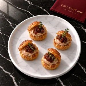 Four portions of Foie-Style Duck Liver & Fig Choux on a white marble plate