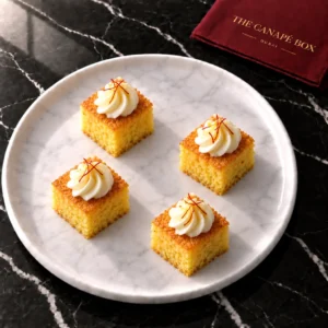 Four portions of Saffron Milk Cake Bite on a white marble plate