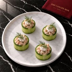 Four portions of Smoked Trout & Horseradish Cucumber Cup on a white marble plate
