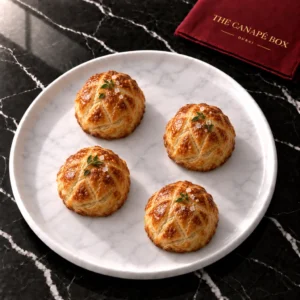 Four portions of Mini Beef Wellington on a white marble plate