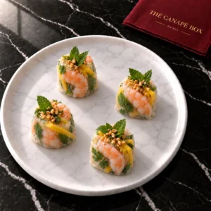 Four portions of Prawn & Mango Rice Paper Roll on a white marble plate