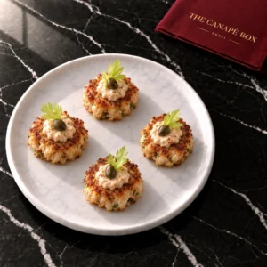 Four portions of Mini Crab Cake with Remoulade on a white marble plate