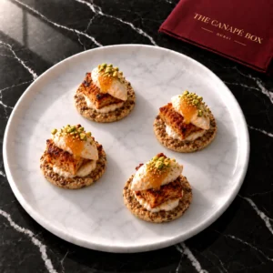 Four portions of Harissa Chicken & Apricot Labneh Bite on a white marble plate