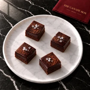 Four portions of Dark Chocolate & Sea Salt Petit Four on a white marble plate