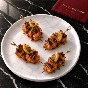 Four portions of Peri-Peri Chicken Skewer on a white marble plate