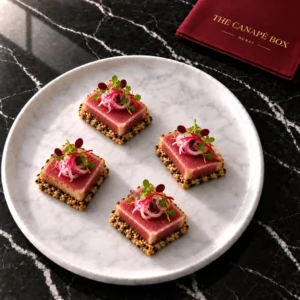 Four portions of Seared Tuna & Sesame on a white marble plate