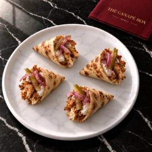 Four portions of Mini Chicken Shawarma Cone on a white marble plate