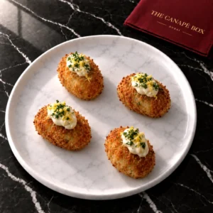 Four portions of Salt Cod Croquette with Aioli on a white marble plate