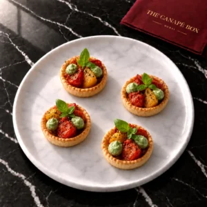 Four portions of Tomato & Basil Tartlet (Vegan Pastry) on a white marble plate
