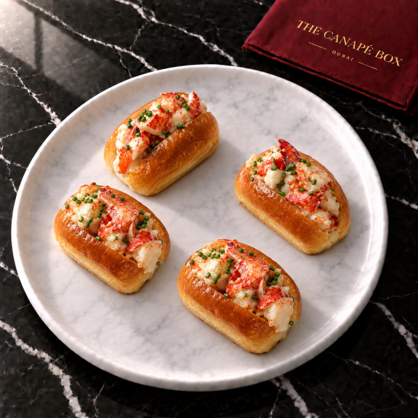 Four portions of Lobster Brioche Bite on a white marble plate