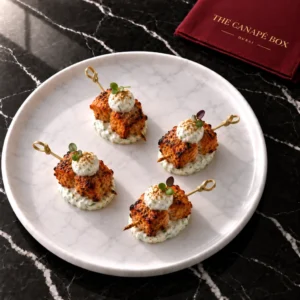 Four portions of Tandoori Chicken Skewer with Raita Pearl on a white marble plate