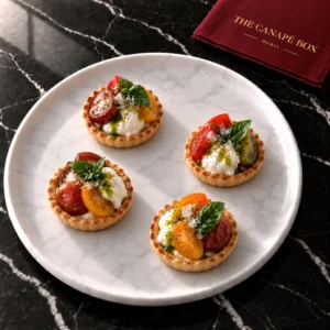 Four portions of Burrata & Heirloom Tomato Tart on a white marble plate