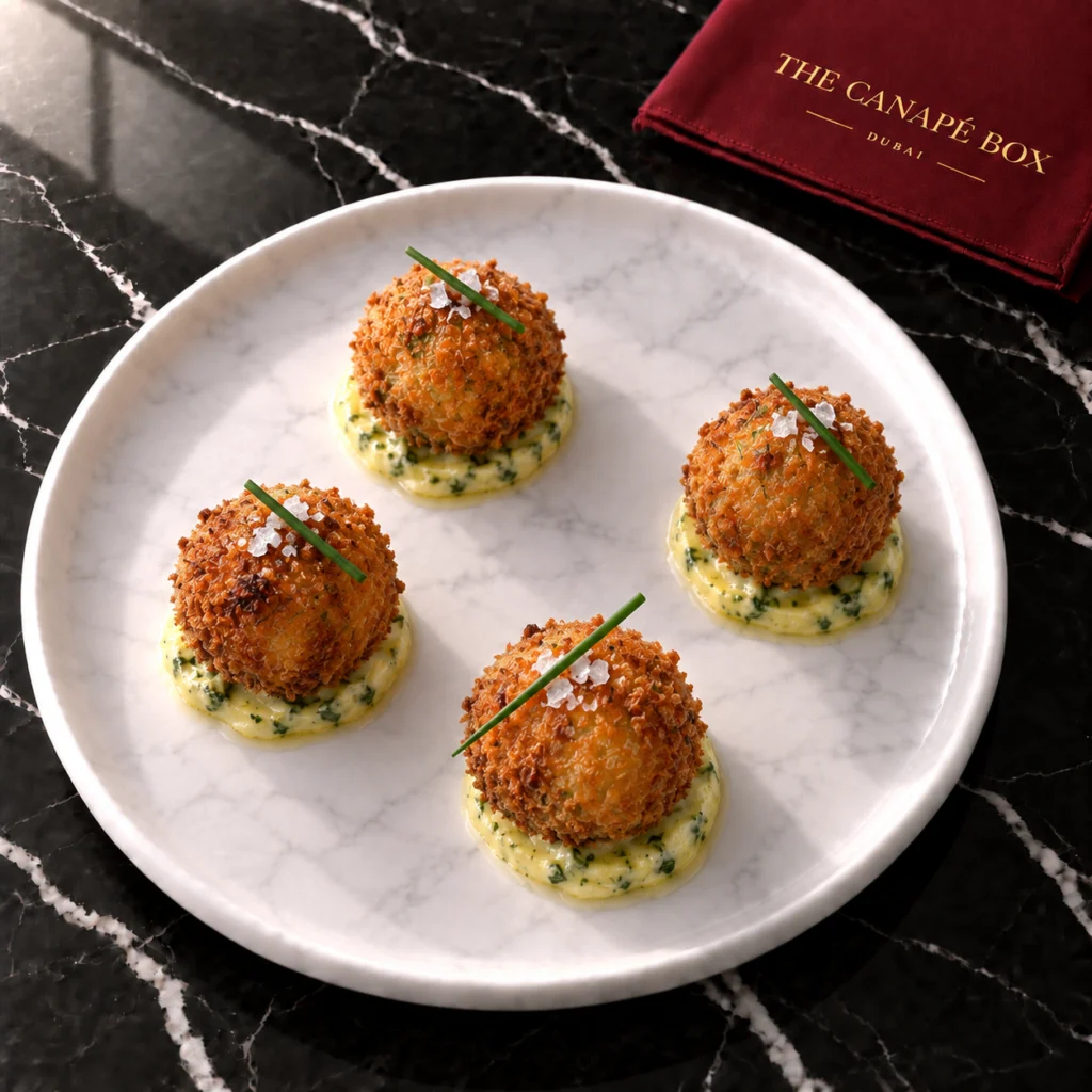 Four portions of Chicken Kyiv Bonbon on a white marble plate
