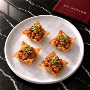 Four portions of Sichuan Pepper Chicken on Crispy Wonton on a white marble plate