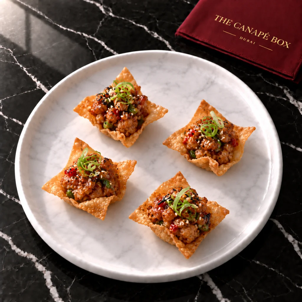 Four portions of Sichuan Pepper Chicken on Crispy Wonton on a white marble plate