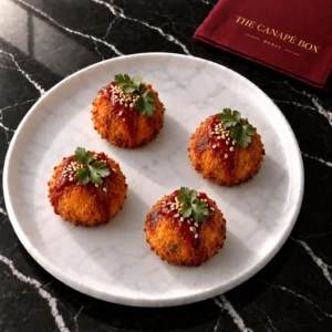 Four portions of Sweet Potato & Harissa Croquette on a white marble plate