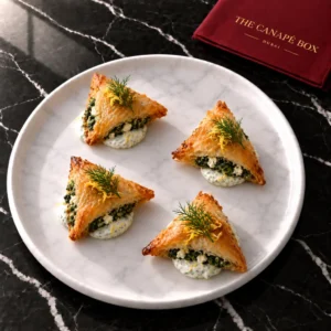 Four portions of Spanakopita Triangle on a white marble plate