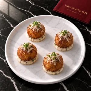 Four portions of Wild Mushroom Arancini with Truffle Mayo on a white marble plate