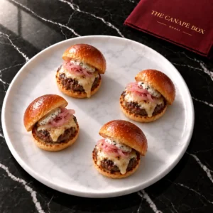 Four portions of Wagyu & Truffle Mini Slider Prestige on a white marble plate