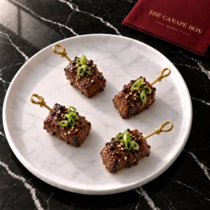 Four portions of Black Pepper Beef Skewer on a white marble plate