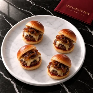 Four portions of Mini Wagyu Slider on a white marble plate