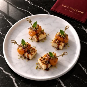 Four portions of Halloumi & Apricot Skewer on a white marble plate