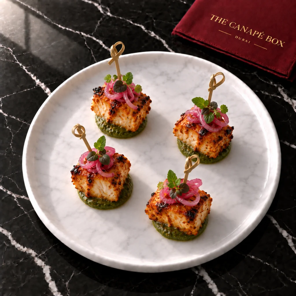 Four portions of Tandoori Fish Tikka Bite on a white marble plate