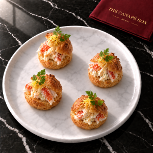 Four portions of King Crab Choux with Citrus Mayo on a white marble plate