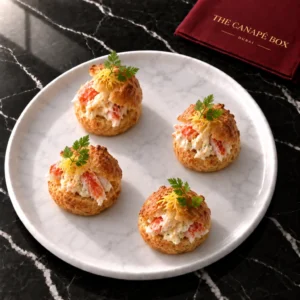 Four portions of King Crab Choux with Citrus Mayo on a white marble plate