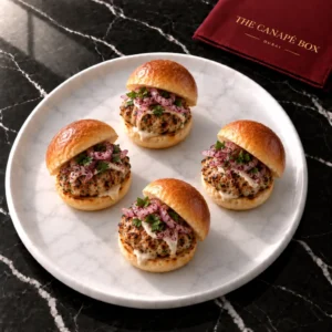 Four portions of Chicken Kofta Mini Slider on a white marble plate