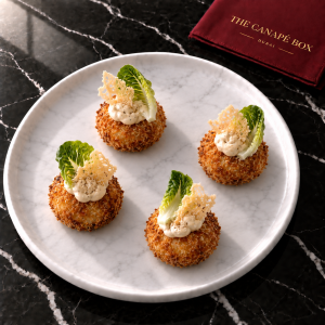 Four portions of Chicken Caesar Croquette on a white marble plate