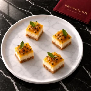 Four portions of Passion Fruit Cheesecake Bite on a white marble plate