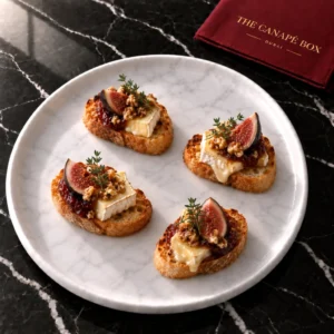 Four portions of Camembert & Fig Crostini on a white marble plate